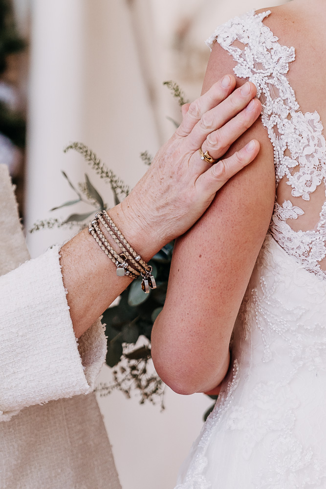 Foto von Lisa Werner Fotografie, Hochzeit, Brautpaar bei der Beglückwünschung, Detailbild, Hand ruht auf dem Arm der Braut