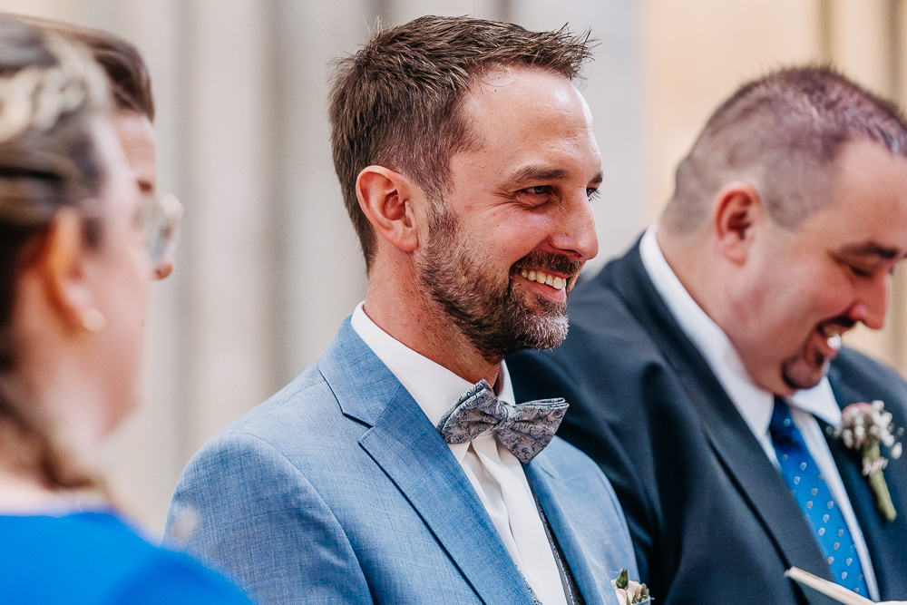 Foto von Lisa Werner Fotografie, Hochzeit, Brautpaar bei kirchlicher Trauung, Bräutigam lacht