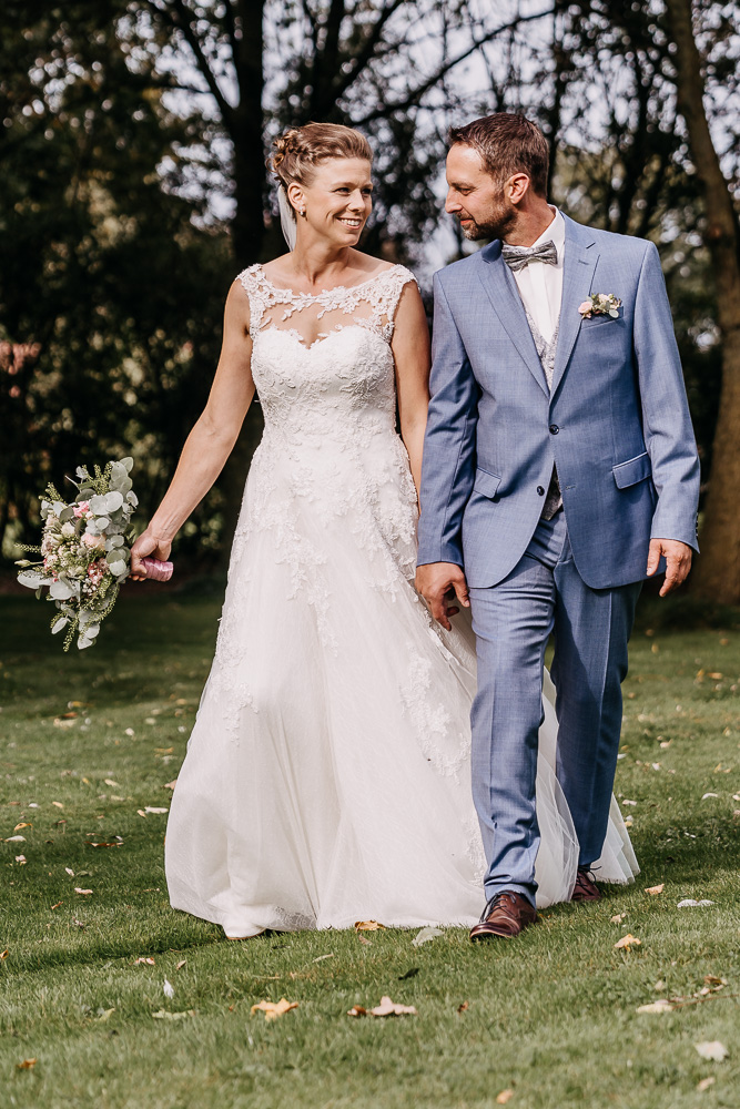Foto von Lisa Werner Fotografie, Hochzeit, Brautpaarshooting, Brautpaar läuft über eine Wiese